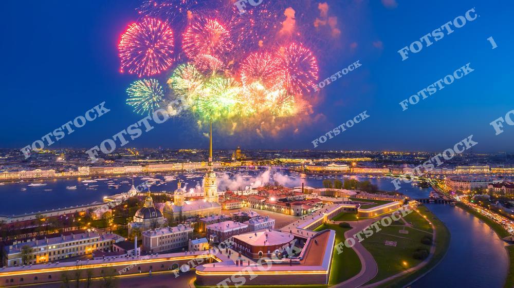 Панорамная фотография Санкт-Петербурга с высоты птичьего полета во время городского праздника. На снимке видны яркий салют над Петропавловской крепостью, акватория Невы и праздничная атмосфера знаменитого события «Алые Паруса». Съемка с дрона позволяет оценить масштаб торжества, красоту вечернего города и архитектуру исторического центра Северной столицы России. Фотография передает атмосферу праздника, огни фейерверков и величие городских достопримечательностей. Снимок идеально подходит для туристических публикаций, фотостоков, рекламы, оформления интерьеров и материалов о культурных событиях Санкт-Петербурга.
